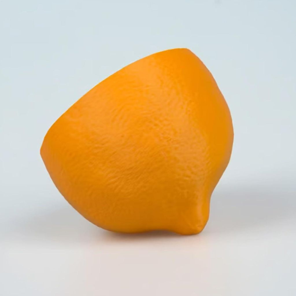 Ein halbiertes, leuchtend oranges Objekt mit einer strukturierten Oberfläche auf weißem Hintergrund.