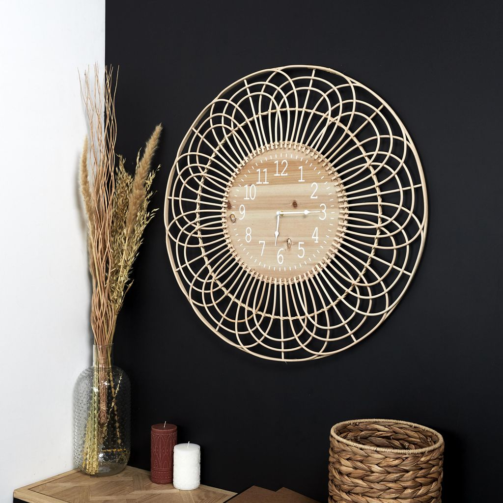 Runde Wanduhr aus hellem Holz mit geflochtenem Rahmen an schwarzer Wand.