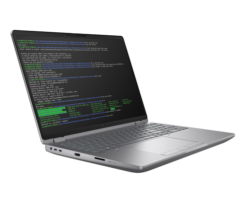 A silver laptop displays green text on a black screen, showing code and file paths.