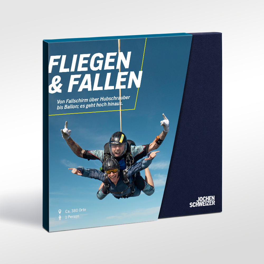 Zwei Fallschirmspringer schweben im Tandemsprung vor blauem Himmel.