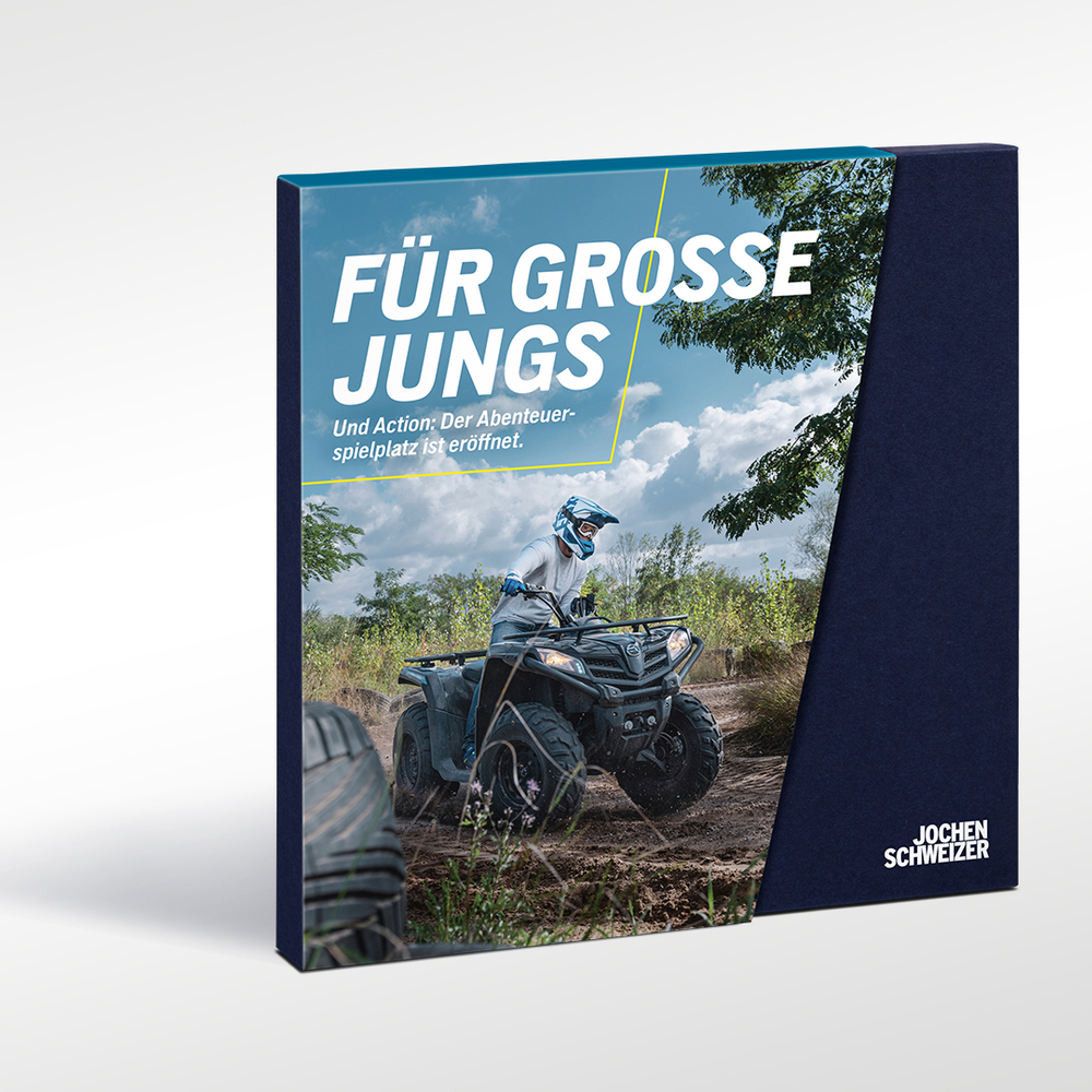 Ein Mann auf einem Quad fährt durch schlammiges Gelände, mit Text "Für große Jungs".