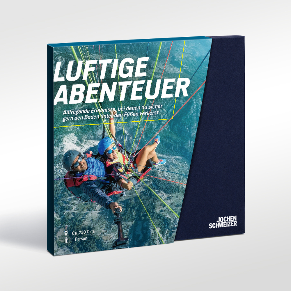 Zwei Personen beim Paragliding über einer Berglandschaft. Text: LUFTIGE ABENTEUER.
