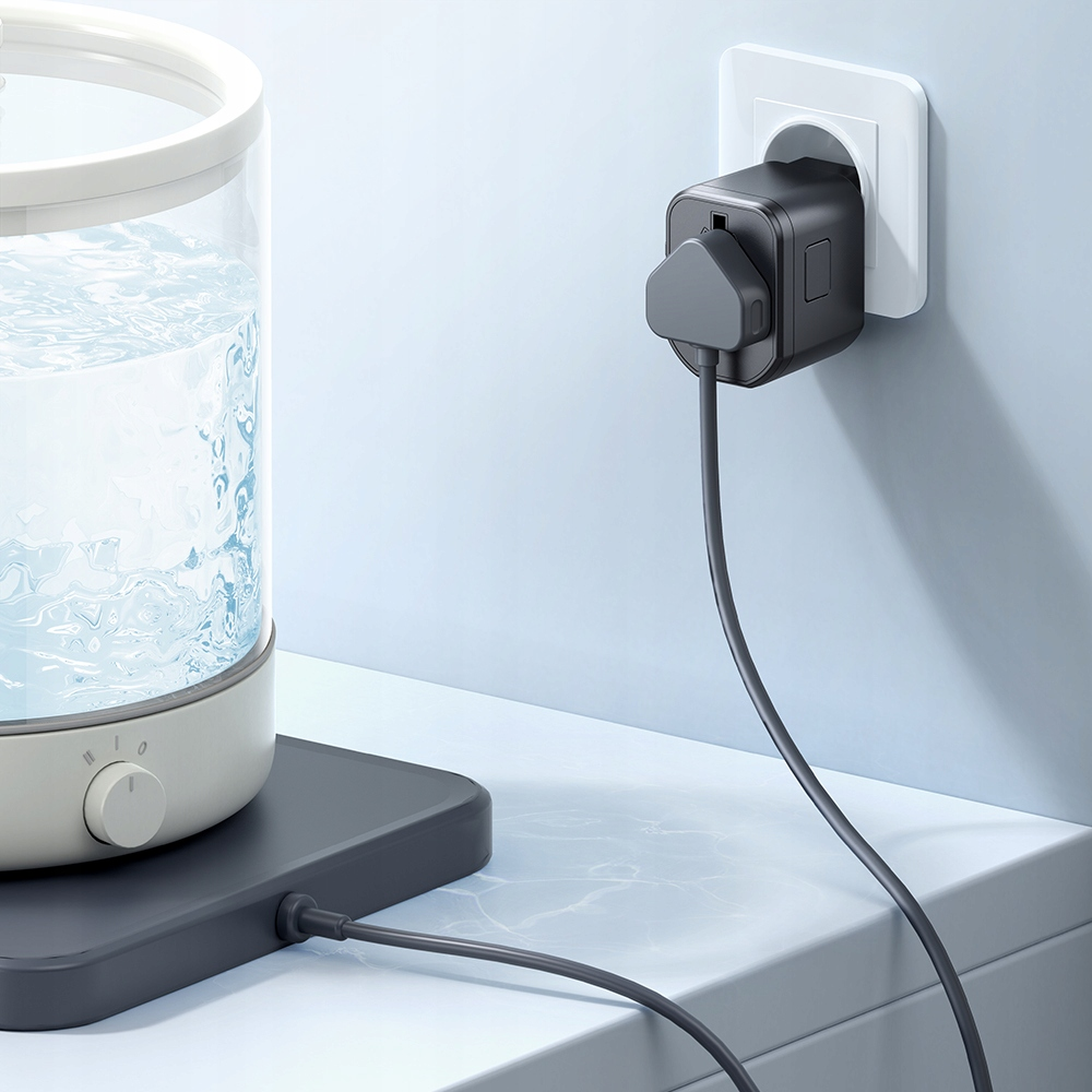 Ein Wasserkocher mit Wasser steht auf einer Arbeitsplatte. Ein Stecker ist in der Steckdose.