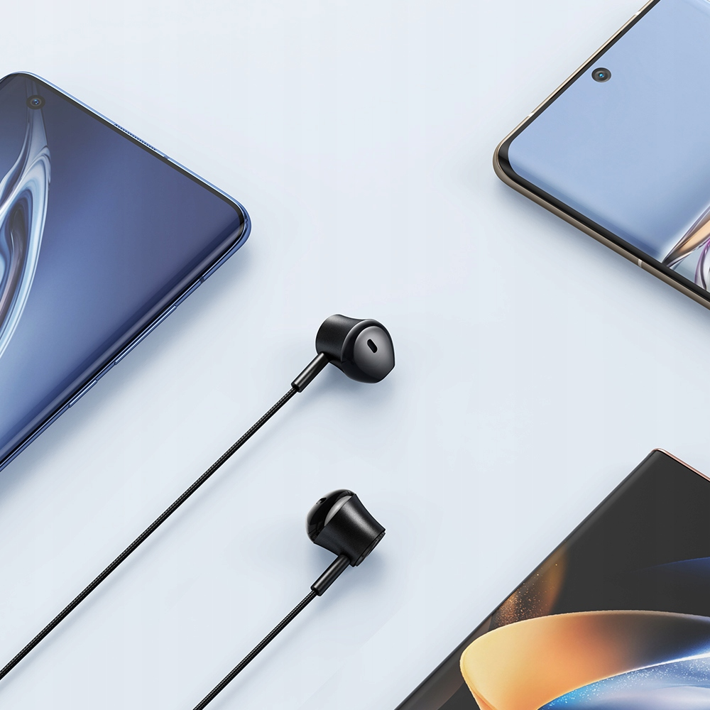 Auricolari neri su sfondo azzurro accanto a tre smartphone.