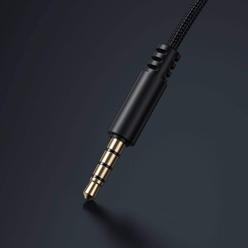 Primo piano di un jack audio dorato da 3,5 mm con cavo intrecciato nero.