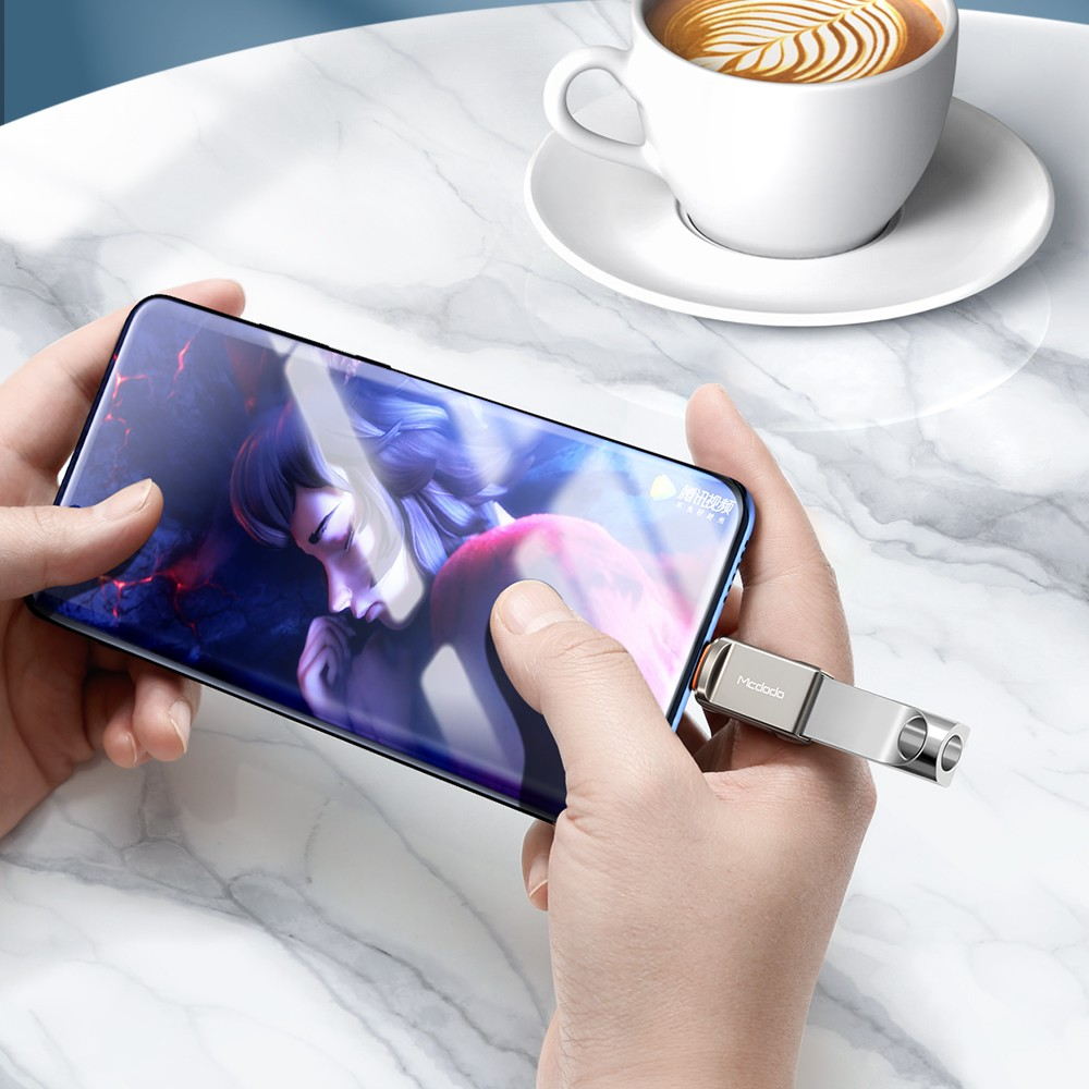 Hände halten ein Smartphone mit Anime-Anzeige. Ein USB-Stick ist angeschlossen.