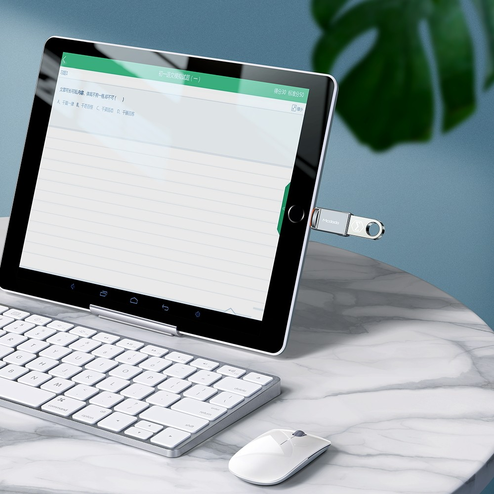 Ein Tablet mit Tastatur und Maus steht auf einem Marmortisch. Ein USB-Stick steckt im Tablet.