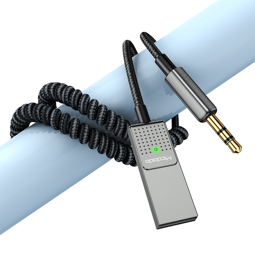Ein grauer Adapter mit einem spiralförmigen schwarzen Kabel und einem 3,5-mm-Stecker.