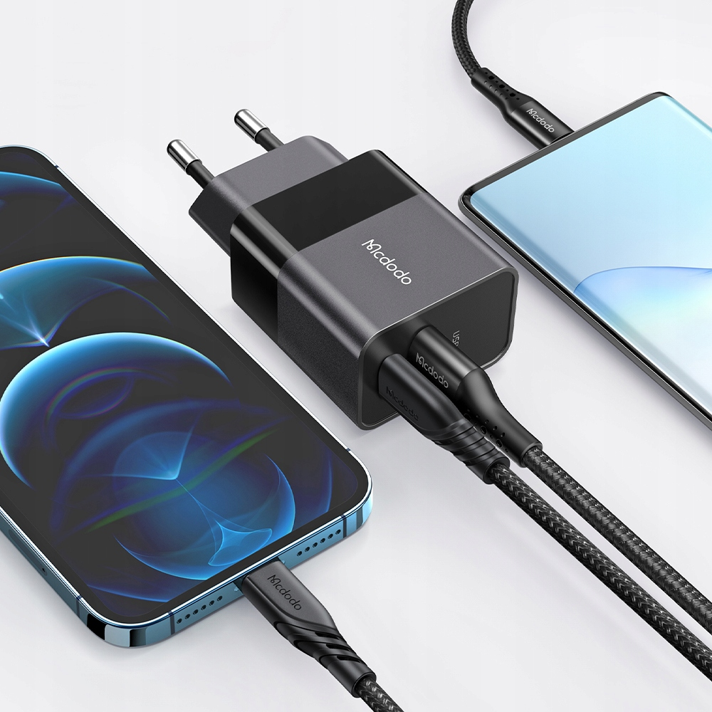 İki telefonu şarj eden iki USB kablolu koyu renkli şarj cihazı.