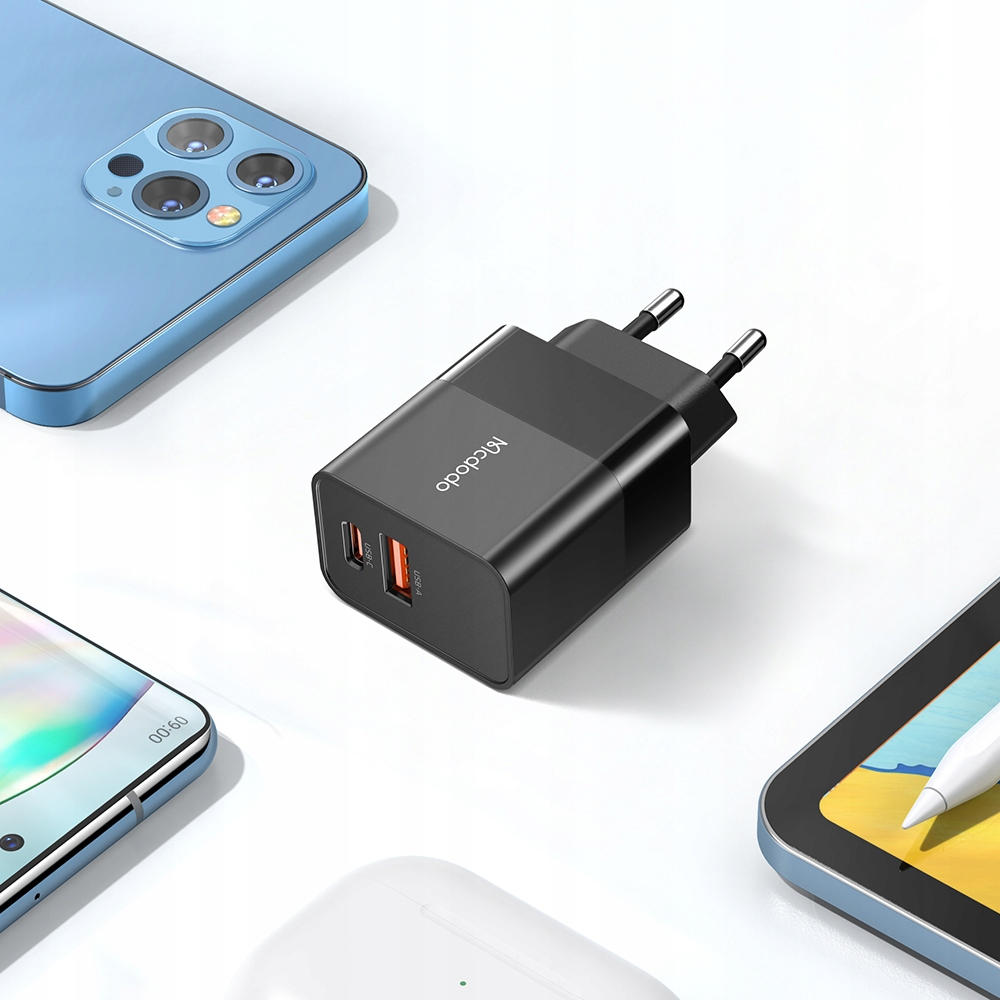 Mavi bir akıllı telefonun yanında iki USB bağlantı noktalı siyah şarj cihazı.