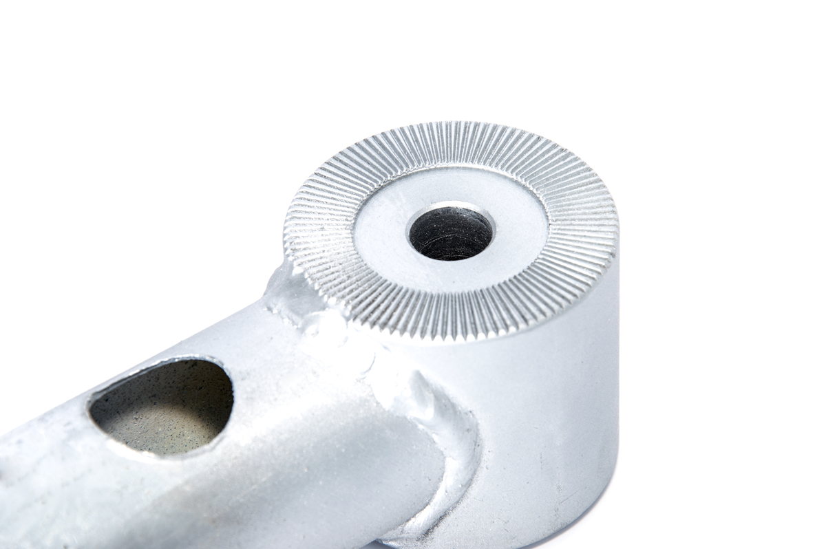Nahaufnahme eines silbernen Metallteils mit einem Loch und einem gerändelten Kopf.