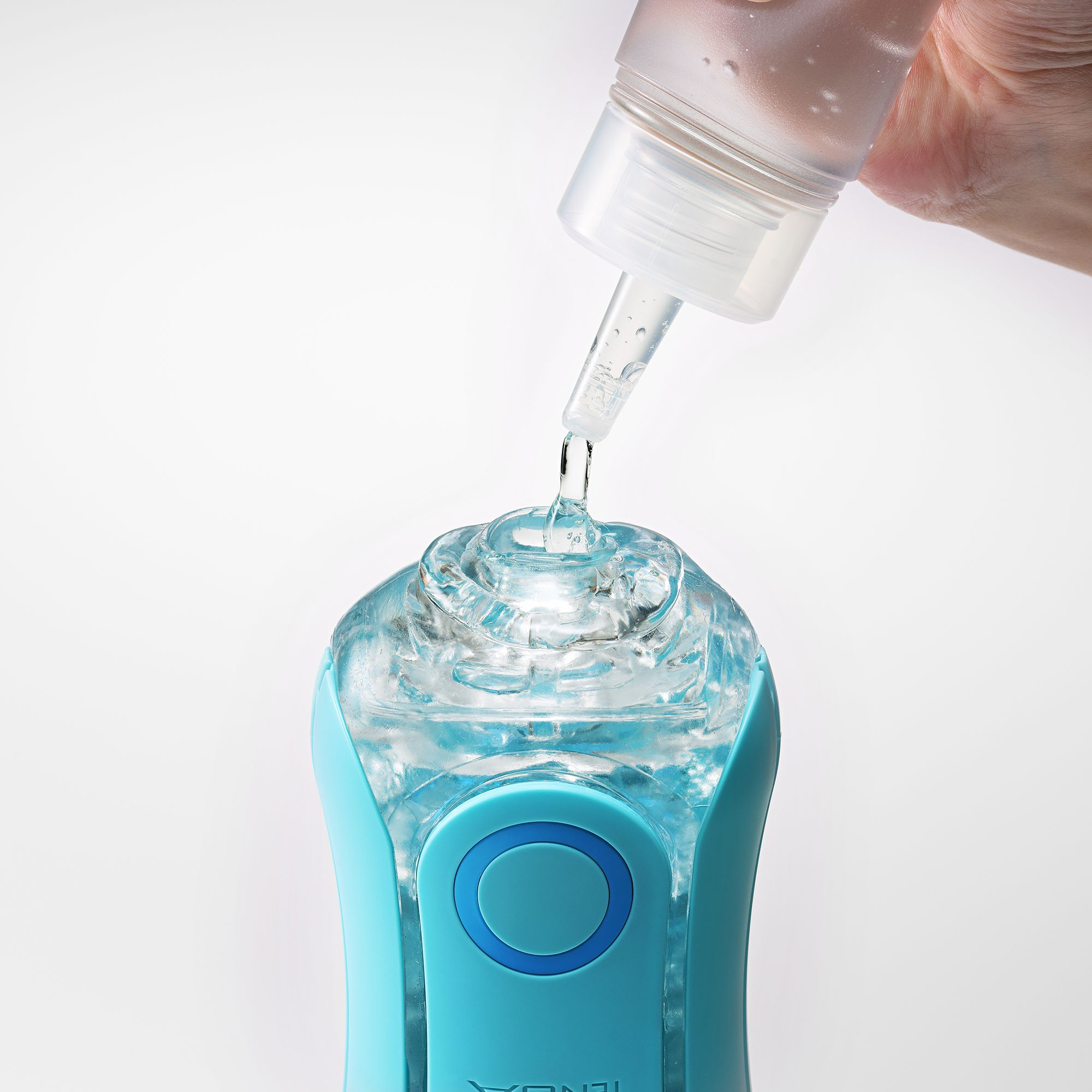 Klare Flüssigkeit tropft aus einer Flasche in ein durchsichtiges, blaues Gerät.