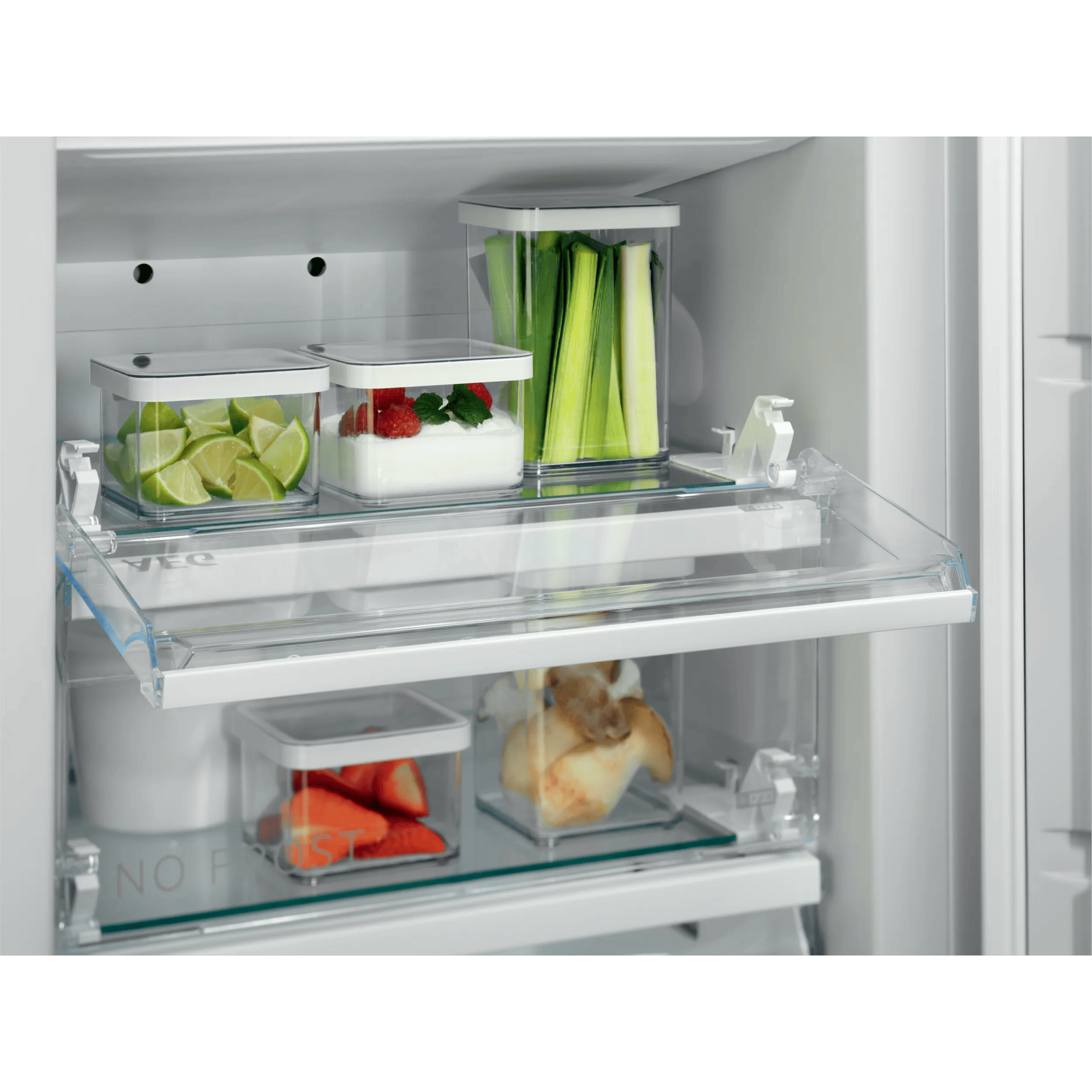 Estante de refrigerador con recipientes: limas, yogur con fresas, apio, fresas, pan.