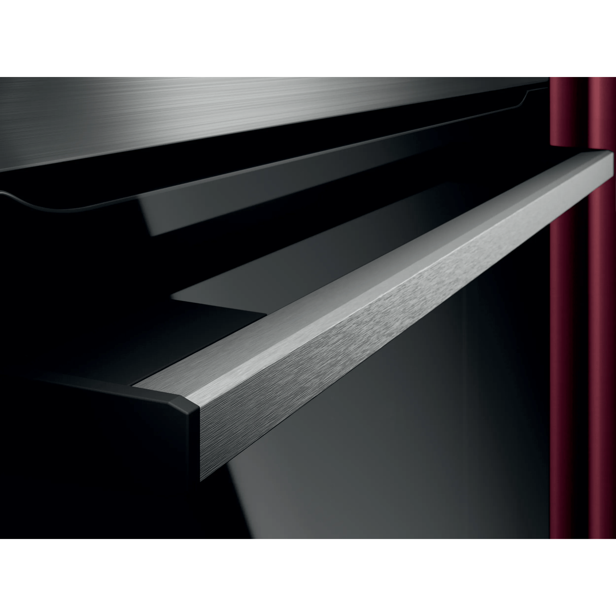 Ein gebürsteter Metallgriff mit schwarzem Hintergrund und roter Säule.