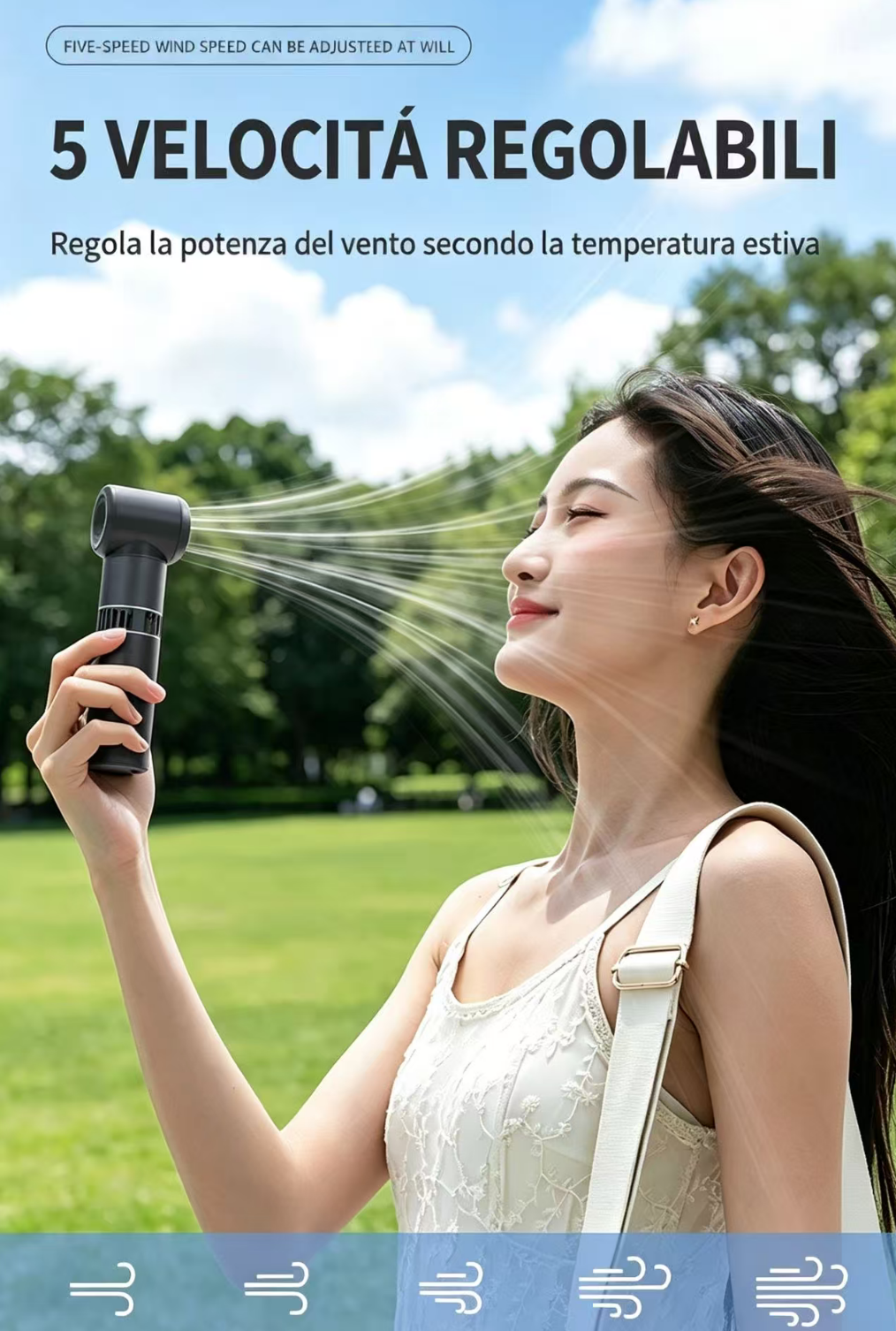 Una donna tiene un ventilatore portatile che soffia aria sul viso all'aperto.