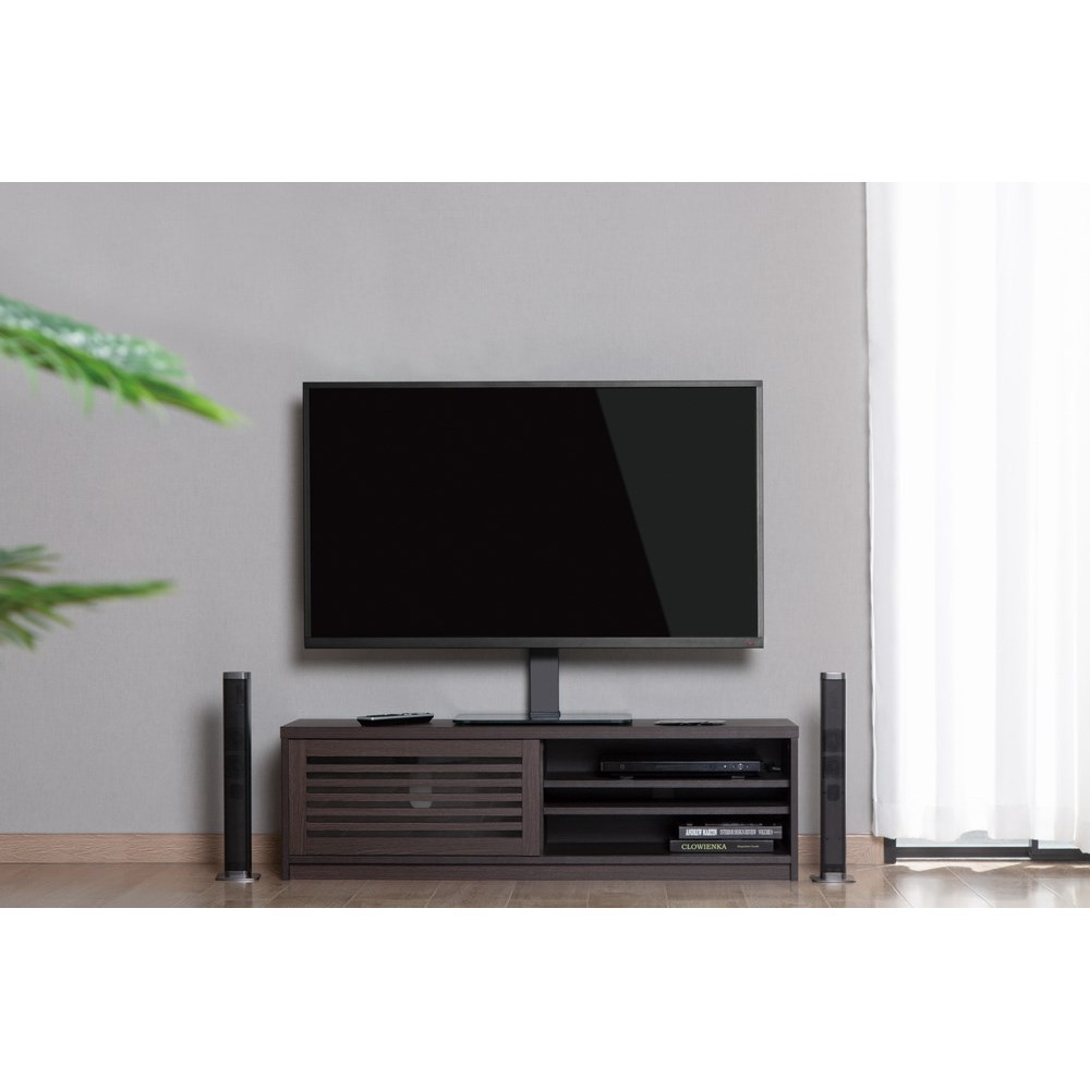 Ciemny telewizor na stojaku nad konsolą multimedialną z głośnikami i pilotem.