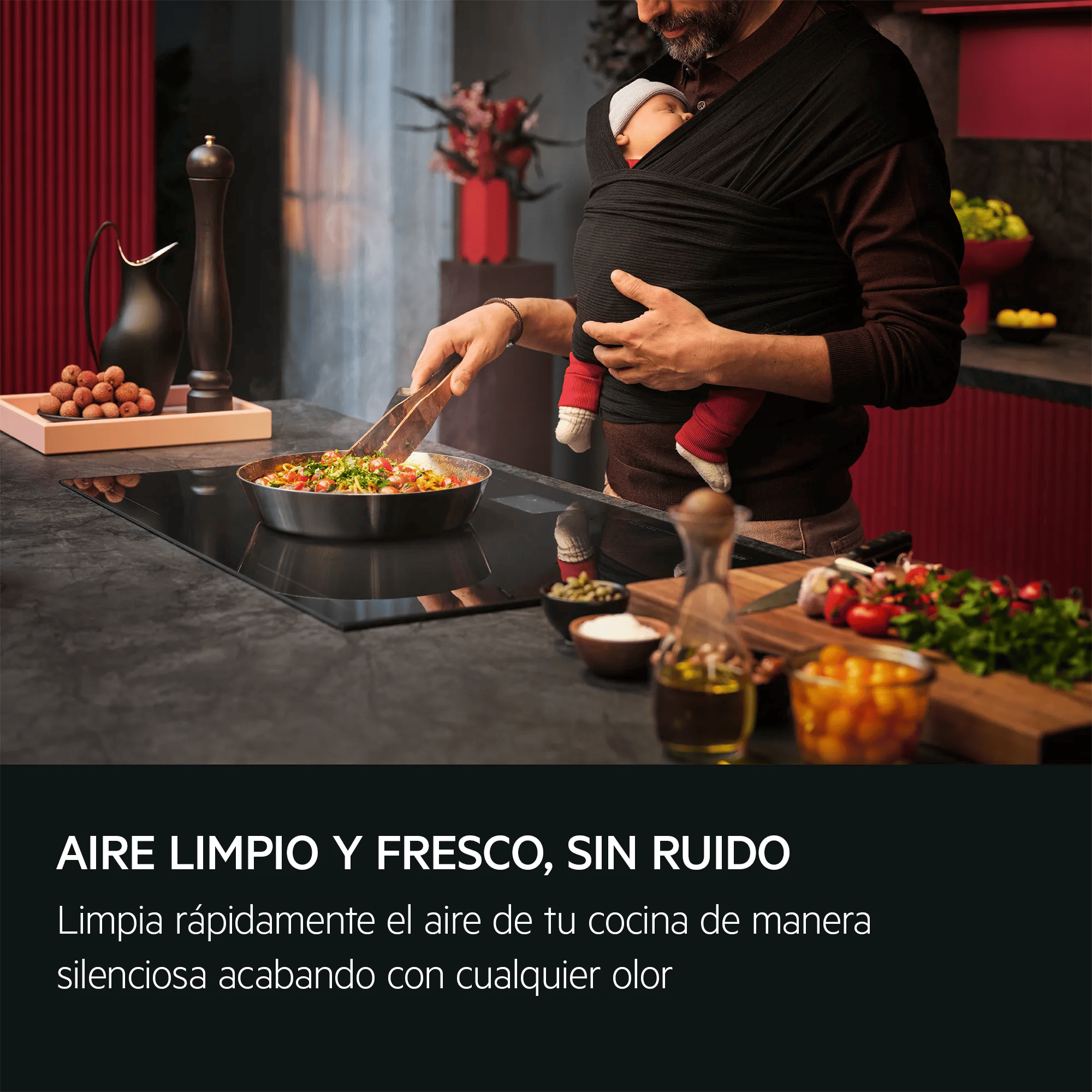 Uomo con bambino in fascia cucina pasta su piano cottura a induzione.