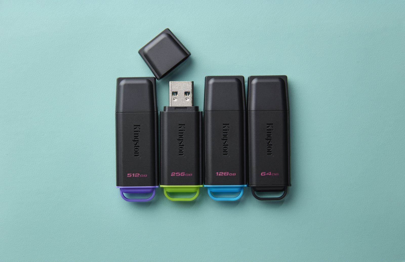 Cztery czarne pendrive'y Kingston o różnych pojemnościach pamięci.
