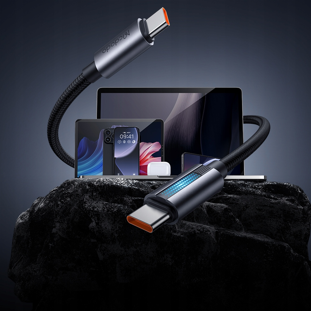 Turuncu konektörlü bir MacDoo USB-C kablosu siyah kayanın üzerinde duruyor.