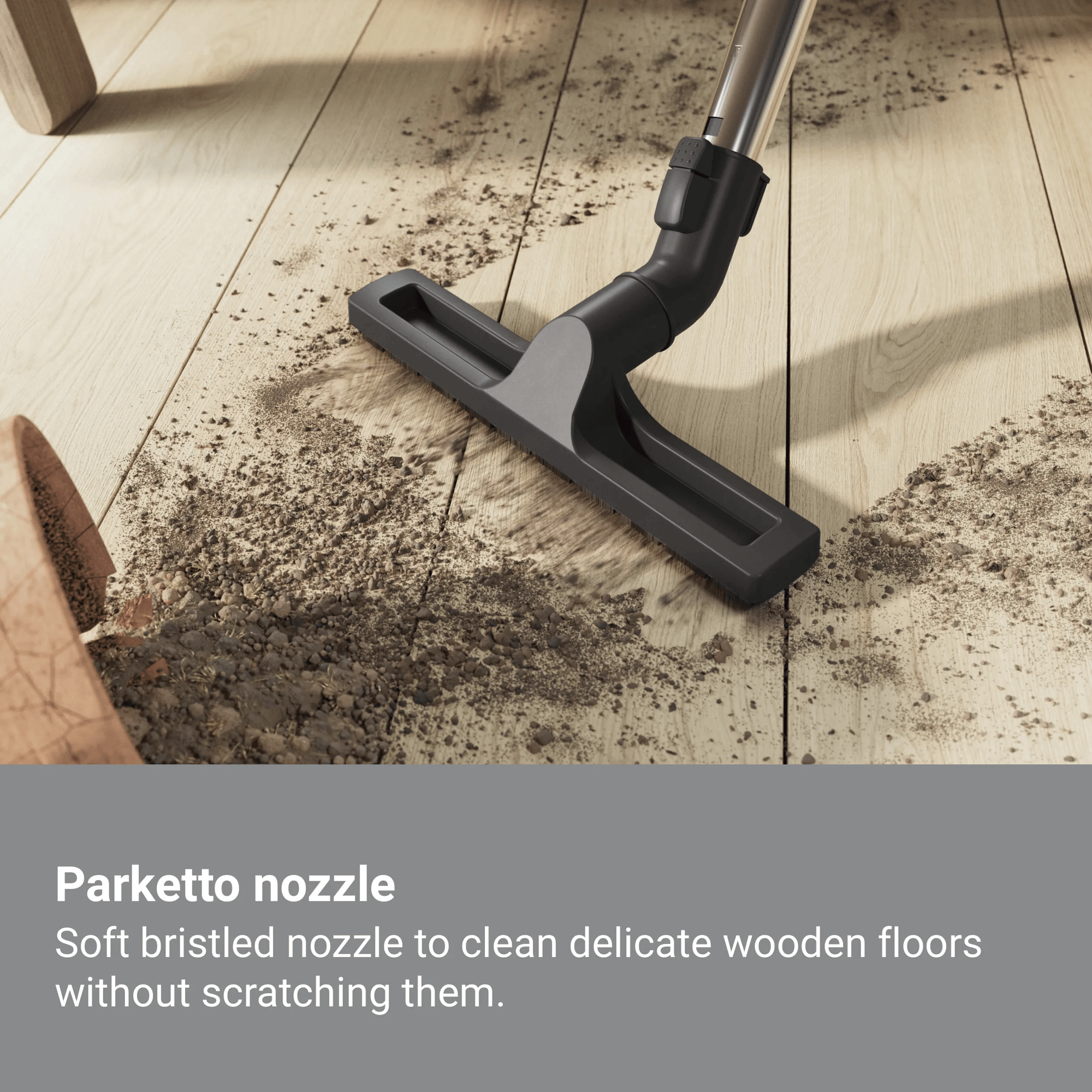 Stofzuiger mondstuk reinigt vuil van houten vloer.