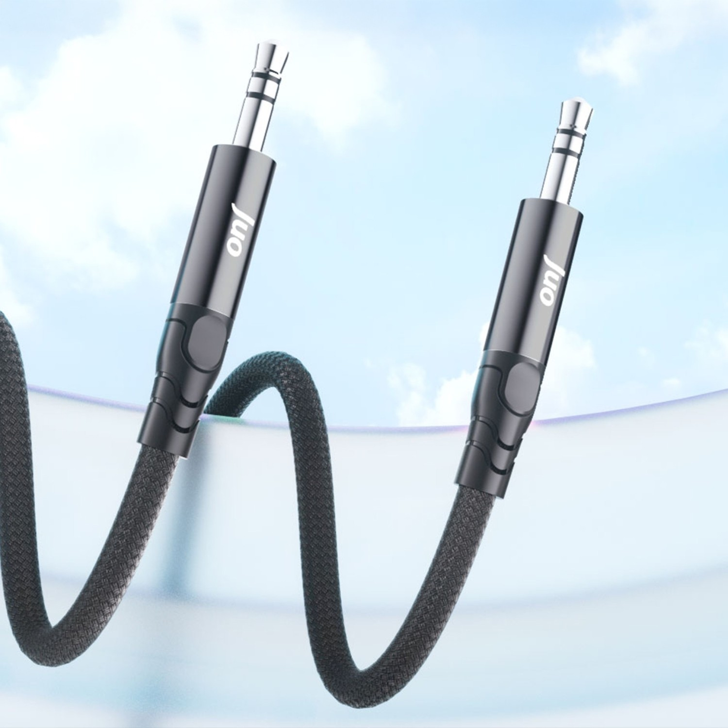 Mavi gökyüzü fonunda iki adet 3,5 mm jaklı siyah ses kablosu.