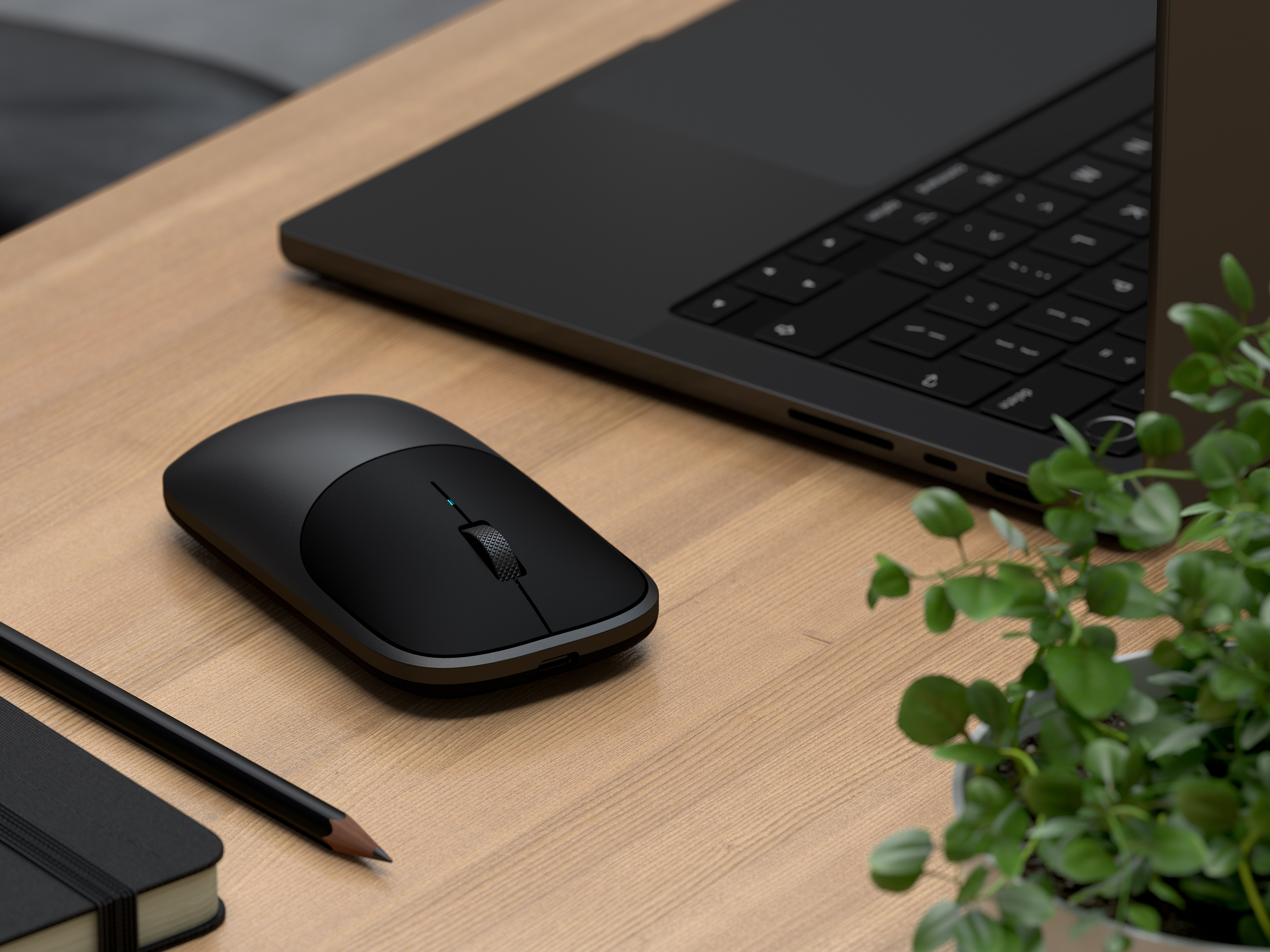 Een zwarte laptop, muis, notitieboekje en potlood op een houten bureau.