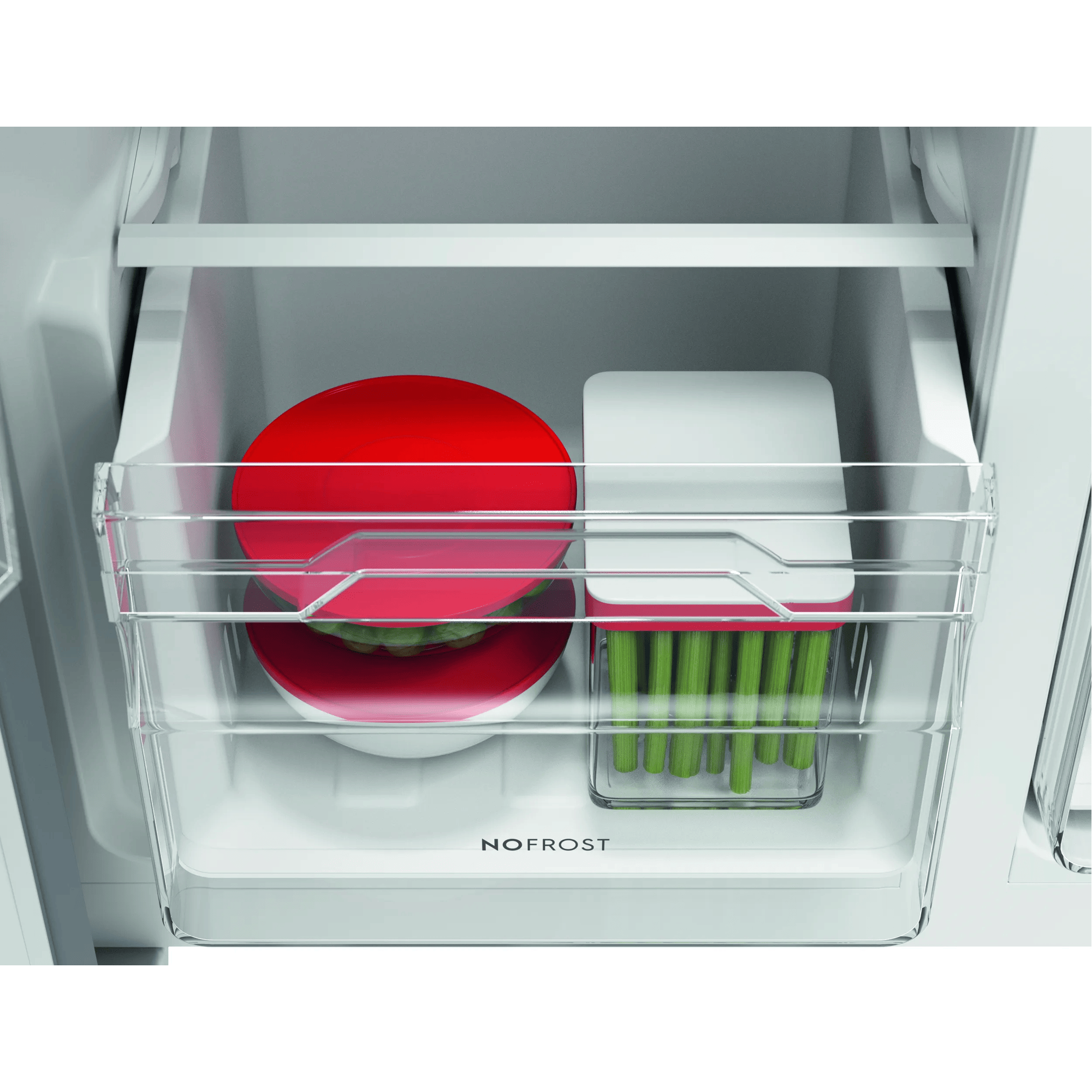Un cajón de refrigerador con un tazón rojo y alimentos verdes.