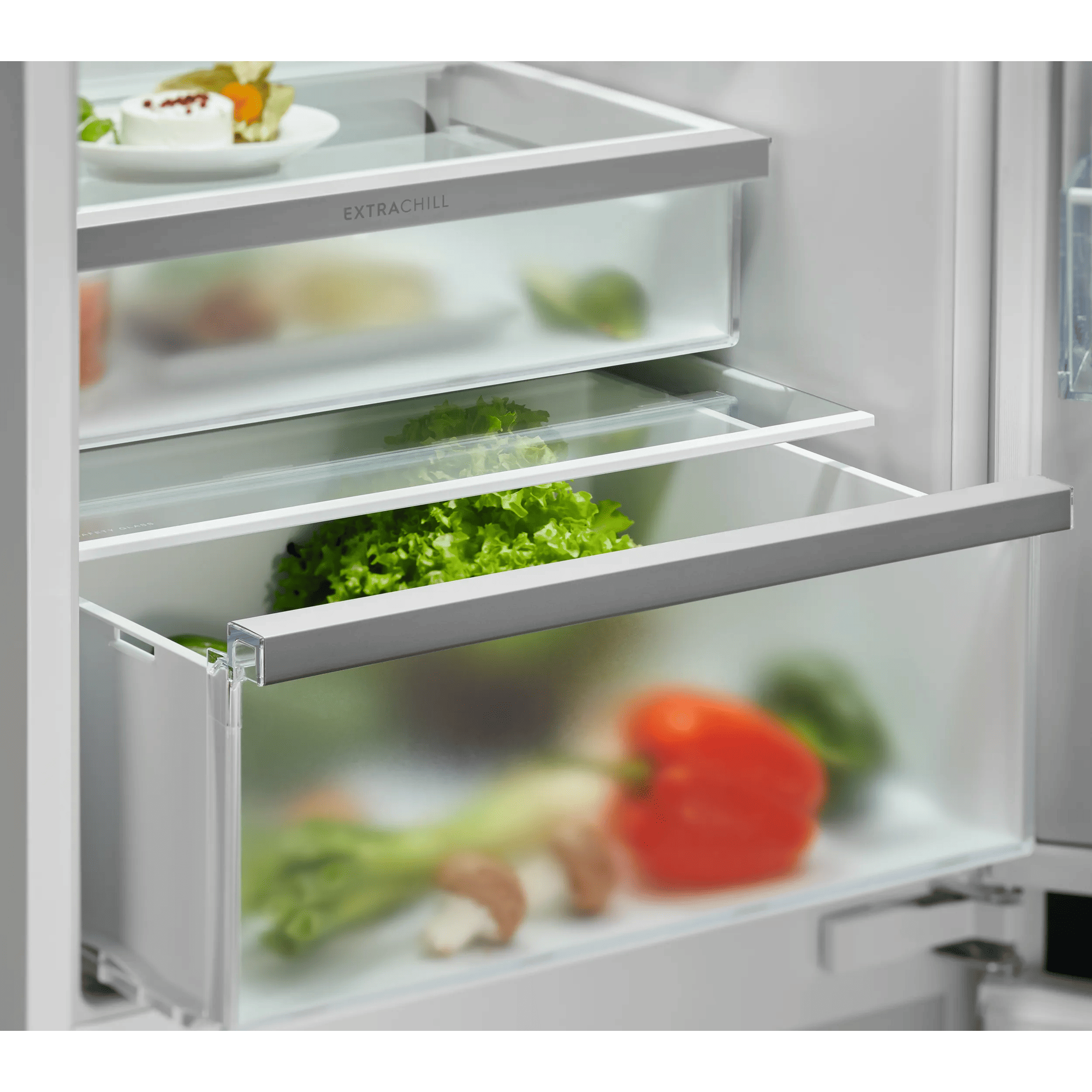 Un cajón de refrigerador con lechuga, pimiento y champiñones. El cajón superior es Extrachill.