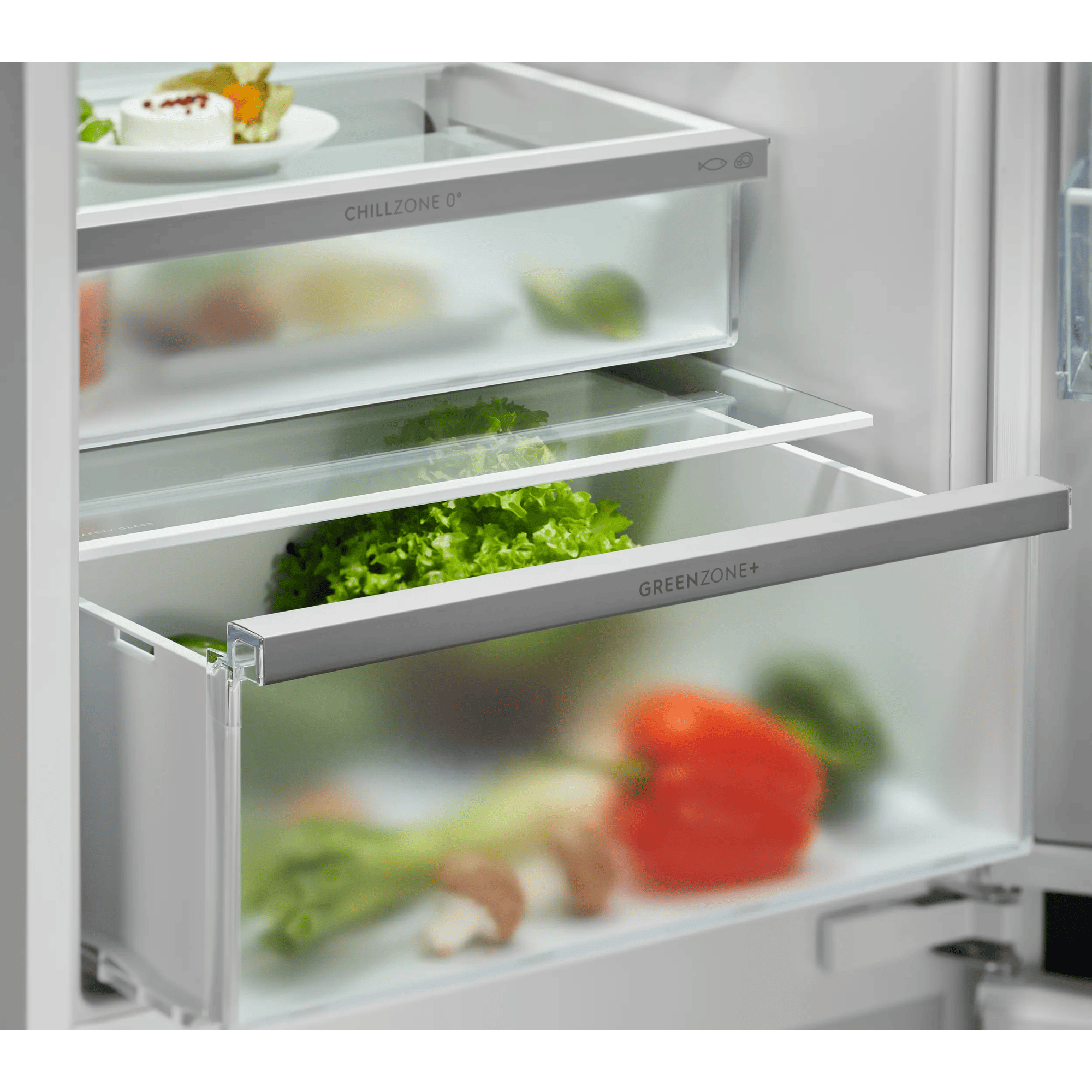 Cajones de refrigerador con frutas y verduras. Un cajón tiene lechuga, el otro pimientos.