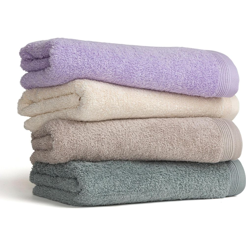 Ein Stapel von vier weichen Handtüchern in Lila, Beige, Grau und Grün auf weißem Hintergrund.