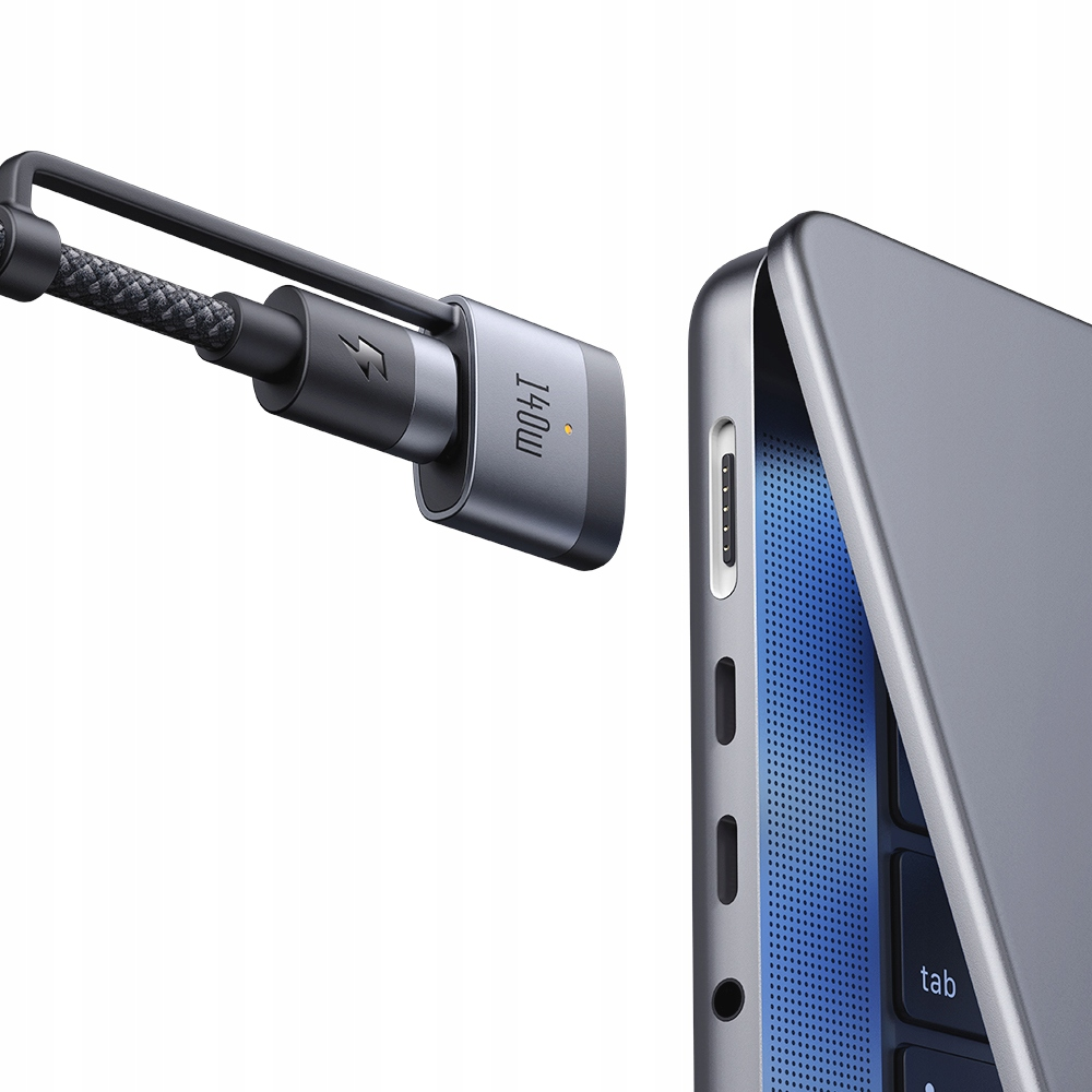 Adattatore di ricarica grigio con simbolo fulmine accanto a un laptop grigio.