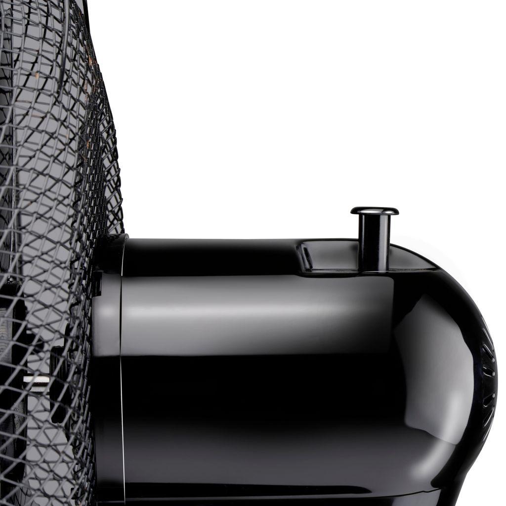 Nahaufnahme eines schwarzen Ventilators mit Schutzgitter und rundem Gehäuse.