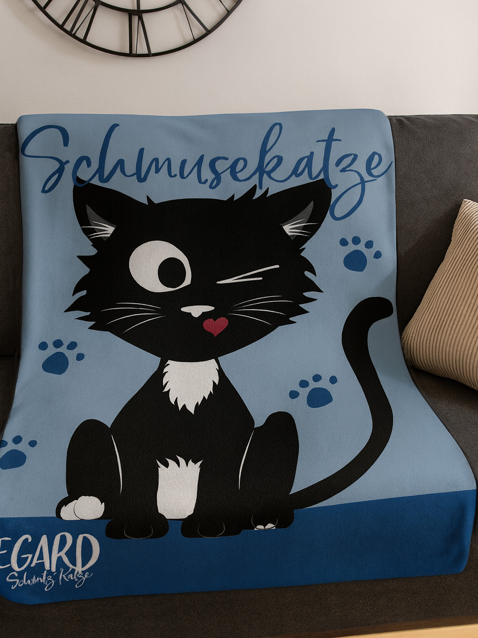 Eine schwarz-weiße Katze mit einem roten Herz auf dem blauen Stoff mit Pfotenabdrucken.