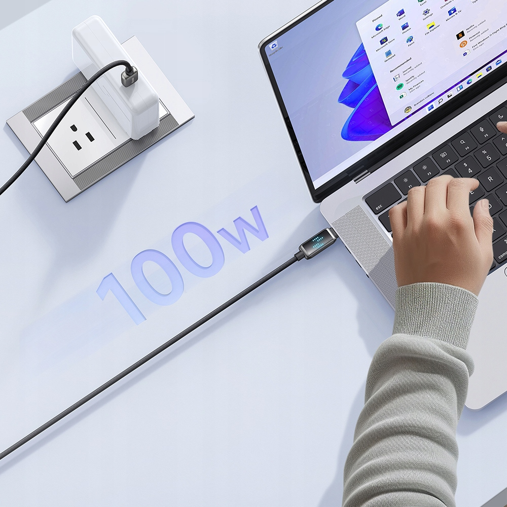 Bir dizüstü bilgisayar, duvar adaptörüne takılı USB-C kablosuyla şarj oluyor.