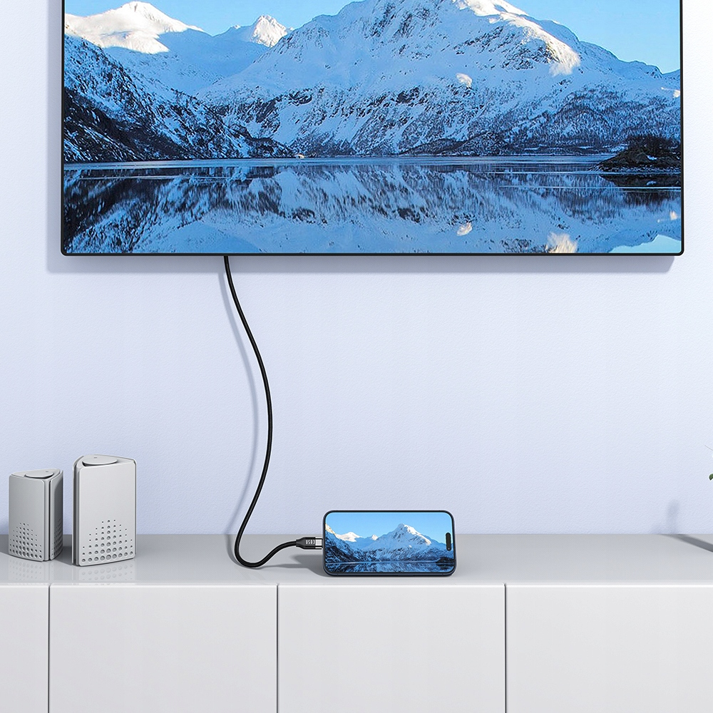 Dağ manzarası gösteren bir TV'ye kabloyla bağlı bir telefon.