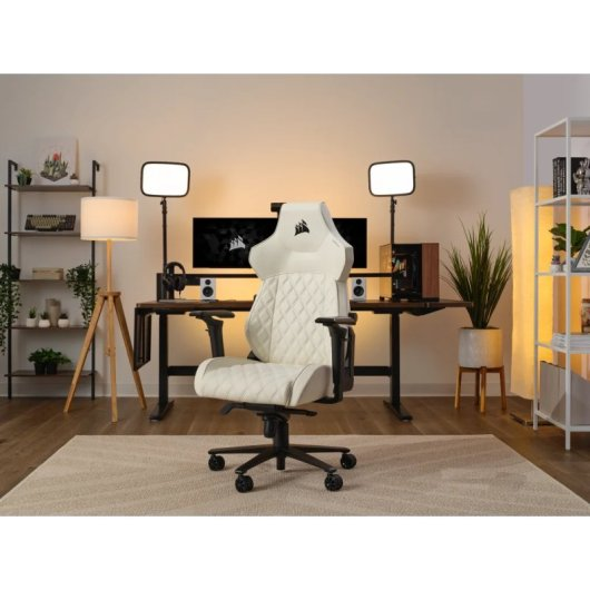 Ein weißer Gaming-Stuhl steht im Fokus, dahinter ein Schreibtisch mit Monitoren.