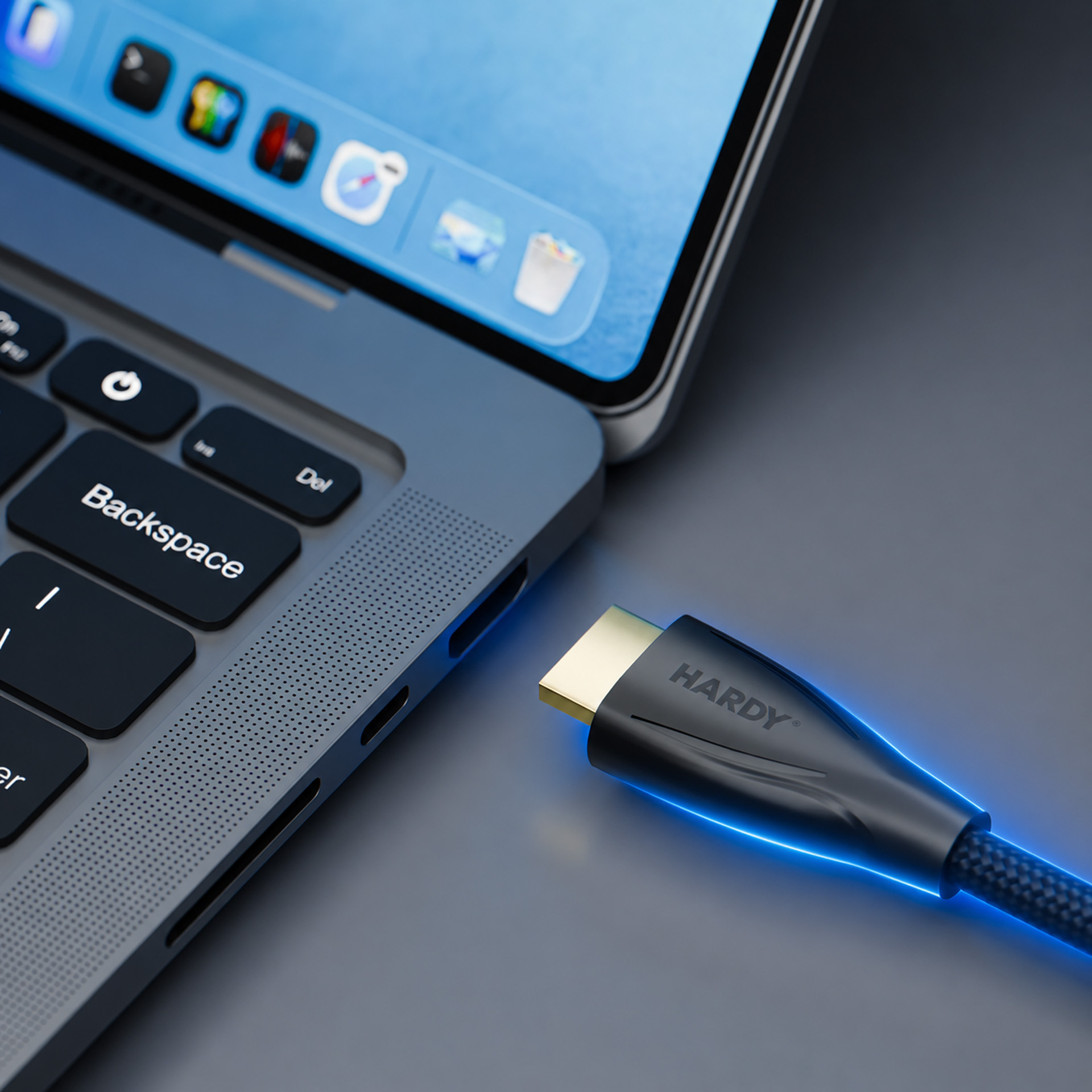 Un cavo HDMI Hardy nero si collega alla porta di un laptop, brillando di blu.