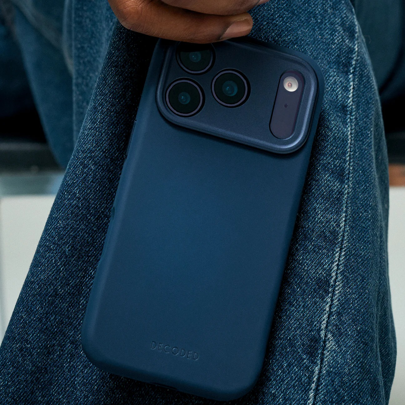 Dunkelblaues Handy mit Kameras auf Jeansstoff.