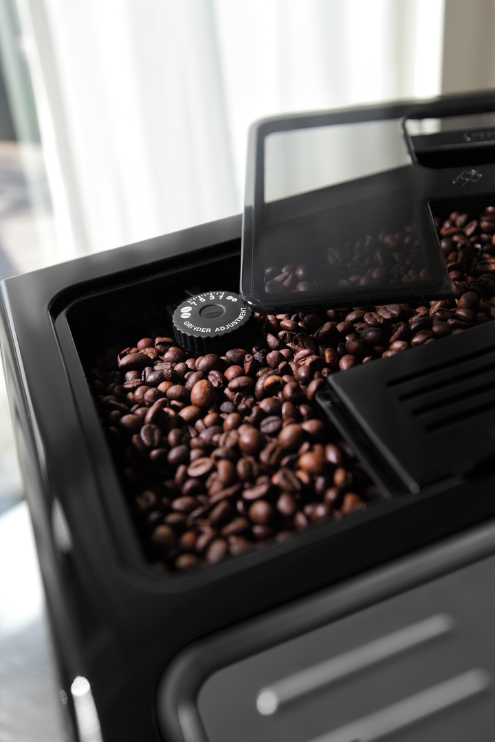 Eine schwarze Kaffeemühle mit vollem Bohnenbehälter und Einstellrad für den Mahlgrad.