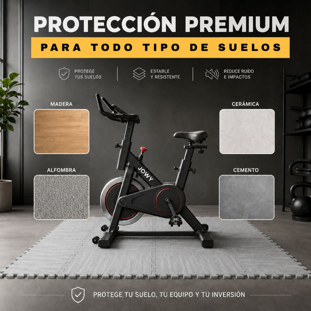 Una bicicleta de ciclismo indoor negra está sobre una esterilla de gimnasio. Se muestran tipos de suelo.