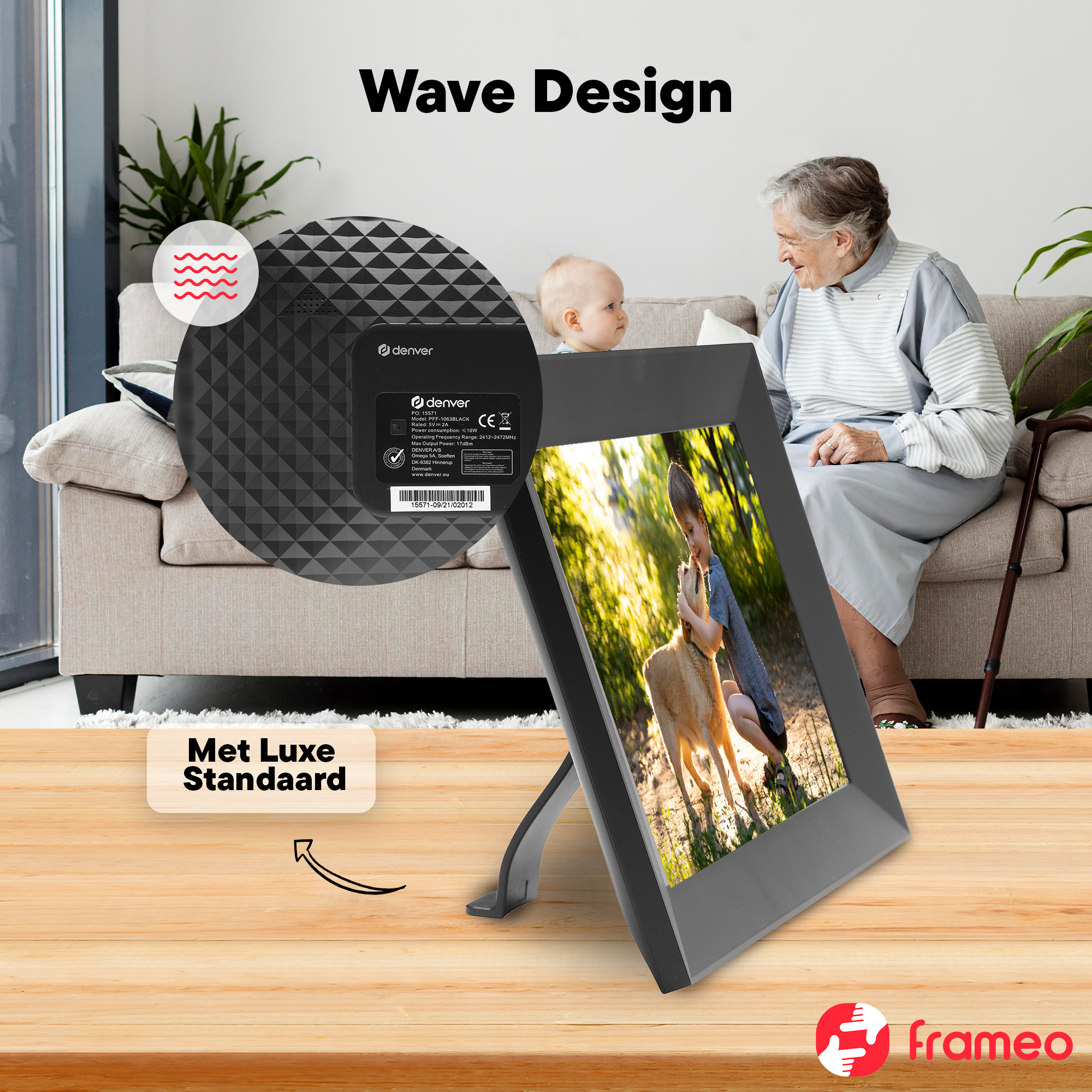 A digital picture frame with wave design on a wooden table. A grandmother and baby sit in the background.