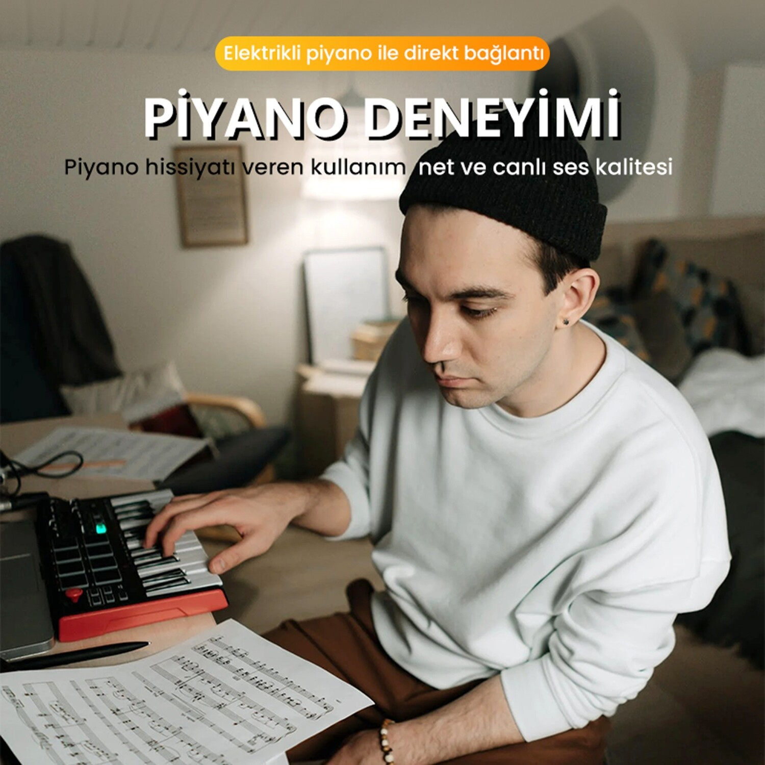 Siyah bereli bir adam, yakında nota kağıtları ile küçük bir klavye çalıyor.