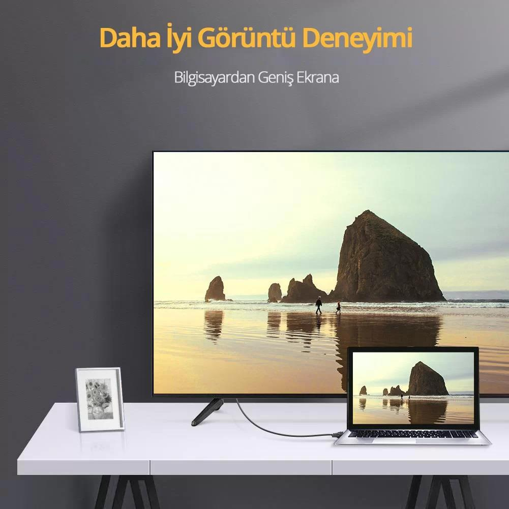 Bir dizüstü bilgisayar bir kabloyla büyük bir TV'ye bağlanır. Her iki ekranda da plaj manzarası gösterilir.