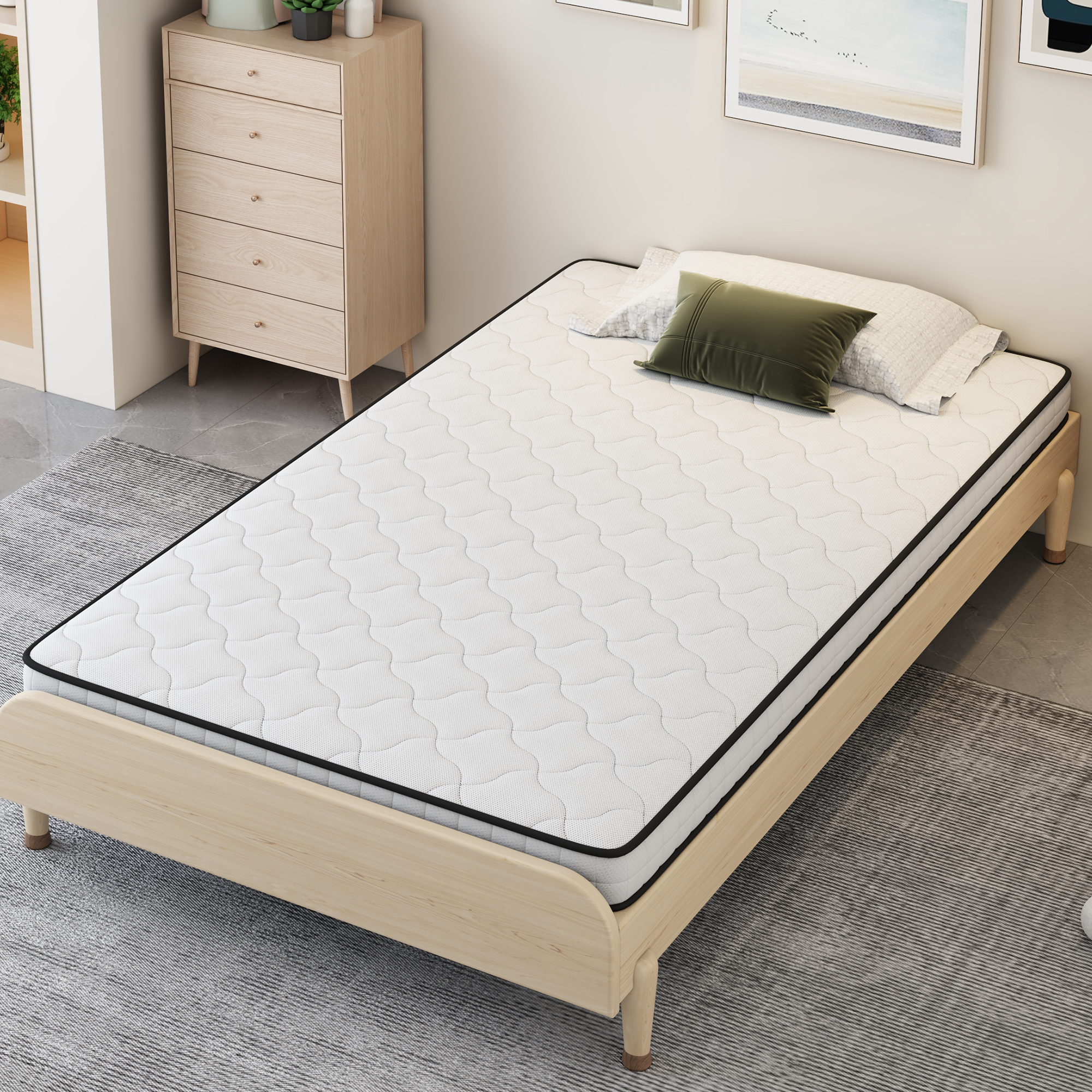 Ein einzelnes Bett mit weißer Matratze, grüner und weißer Zierde auf einem Teppich.