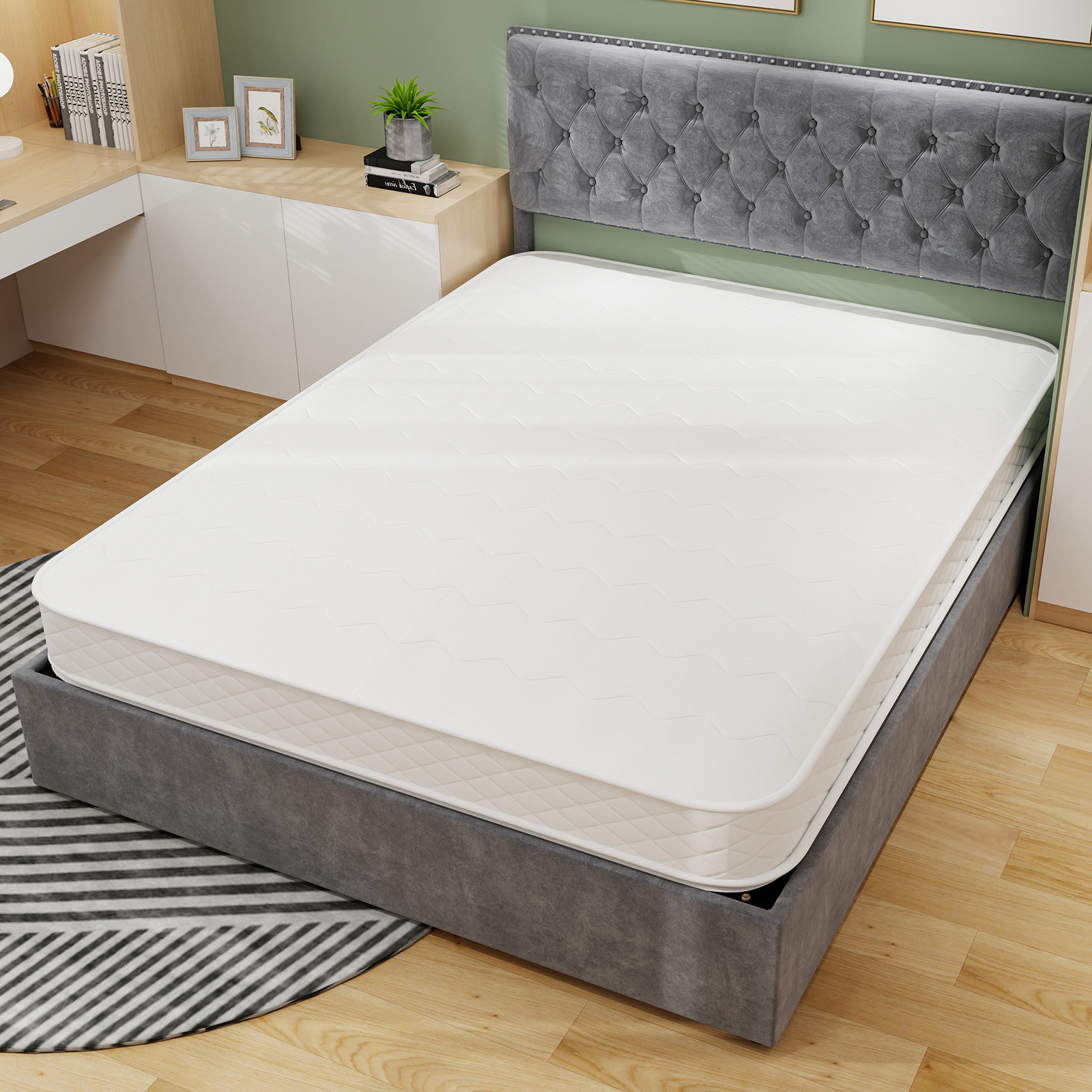 Ein weißes Bett mit grauem Kopfteil und einem runden Teppich.