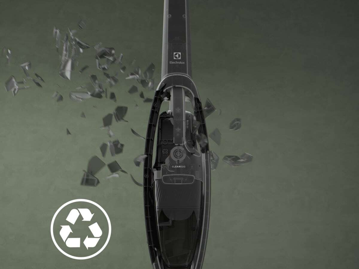 Ein staubsaugerteil schwebt vor einem grünen Hintergrund mit zerbrochenem glas und einem recycling-symbol.