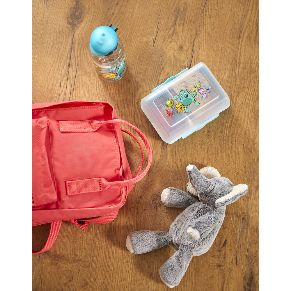 Ein rosafarbener Rucksack, eine Brotdose und eine Wasserflasche liegen auf einem Holzboden.