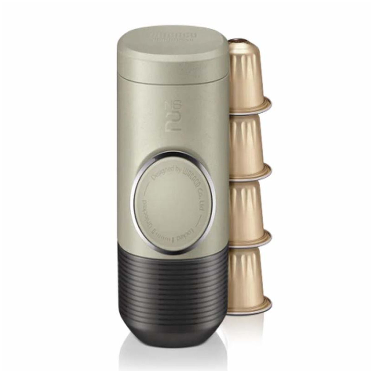 Eine beige und anthrazitfarbene Kaffeemaschine mit drei goldenen Kaffeekapseln daneben.