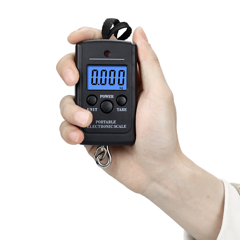 Eine Hand hält eine schwarze digitale Waage mit der Anzeige 0.000 kg.