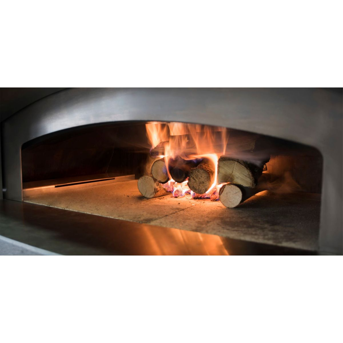 Holz brennt in einem Steinofen mit Flammen und Funken.